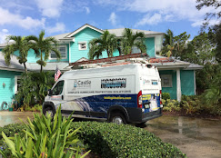 Service van with installation equipment parked outside a teal Florida home during impact window, door, and shutter installation.