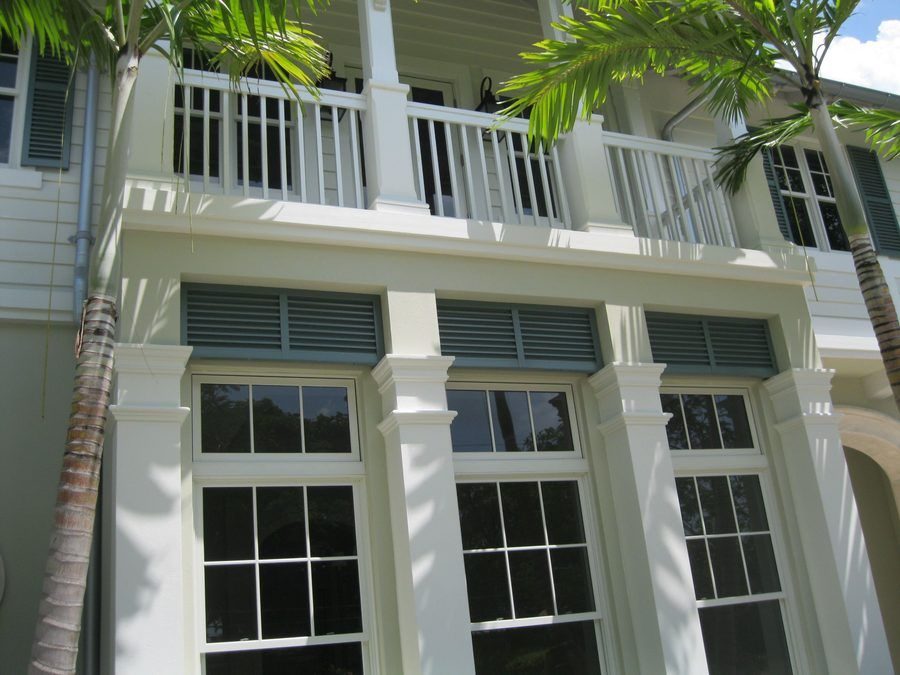 Large white-framed windows with palm trees in a tropical setting