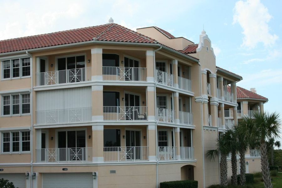 Condominium building in West Palm Beach surrounded by palm trees underneath a clear, blue sky